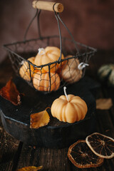 Handmade wax candle in the shape of pumpkins on a dark background
