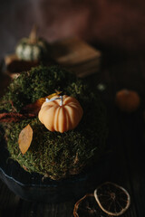 Handmade wax candle in the shape of pumpkins on a dark background