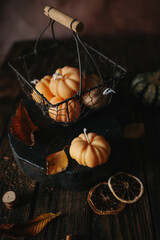 Handmade wax candle in the shape of pumpkins on a dark background