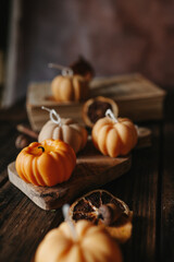Handmade wax candle in the shape of pumpkins on a dark background