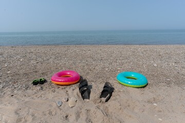 Beach scene with inflatables and sandals