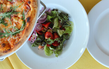 Pizza On Pan Riser Stand Over Served Plate With Fresh Salad At Italian Cafe 
