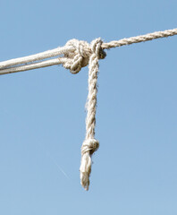 A white rope is hanging from a blue sky