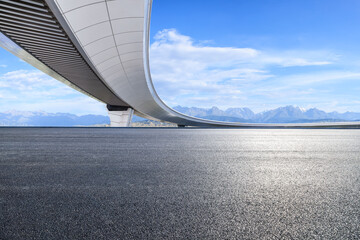 Asphalt road and bridge with mountain nature landscape under blue sky. Road trip.