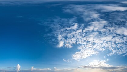 A panoramic view of a bright blue sky adorned with fluffy clouds, capturing the serene beauty of daytime.