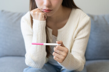 Sad, Disappointed motherhood asian young woman hand holding pregnancy test, upset ovulation...