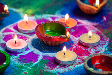Clay diya lamps lit during diwali celebration. Indian festival Diwali, Diya oil lamps lit on colorful rangoli. Hindu traditional.
