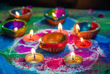 Clay diya lamps lit during diwali celebration. Indian festival Diwali, Diya oil lamps lit on colorful rangoli. Hindu traditional.