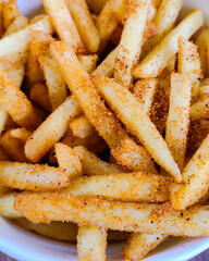 A close up of french fried with ground spices in a cup. 
Can be used for food menu photos