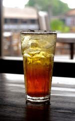 A glass of iced tea on a table with a bokeh background