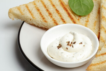 Cup with cheese sauce on the kitchen table.