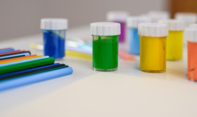 Akcesoria do malowania, kredki i kolorowe farbki na biurku © Paweł Kacperek