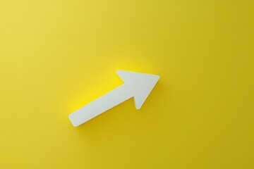The image features an inclining white 3D arrow installed against a vibrant yellow wall, creating a striking visual contrast.
