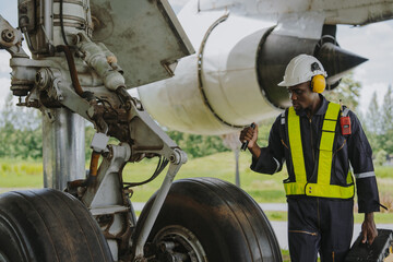 Mechanics inspect the engines of a large plane before takeoff at a summer airport.