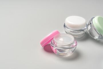 Colorful cosmetic containers arranged neatly on a light gray background