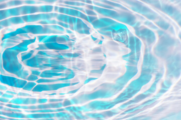Blue water with ripples on the surface. Defocus blurred transparent blue colored clear calm water surface texture with splashes and bubbles. Water waves with shining pattern texture background.
