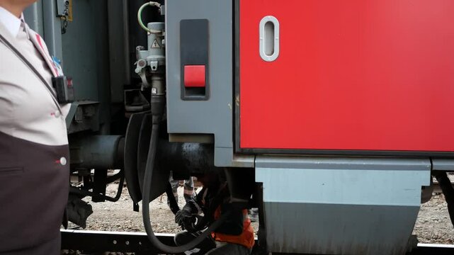 Coupling of the railway car and shunting locomotive on the rails. Close-up. the moment the diesel locomotive is connected to the railway car. A male worker couples train wagons.
