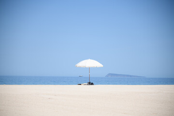 White umbrella on a blue beach and calm sea