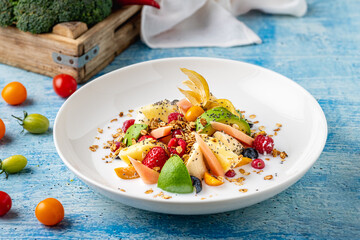 Mixed fruit salad with fruits such as banana, strawberry and pineapple on a white porcelain plate
