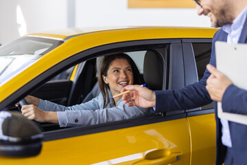 Car Renting Service. Young Woman Driver Taking Keys From Manager While Sitting In Rental Auto, Smiling woman Enjoying Vehicle Leasing, Cropped Image, Closeup