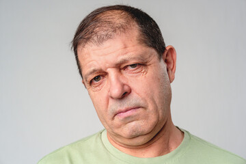 Obraz premium Middle-aged man with a thoughtful expression against a plain background