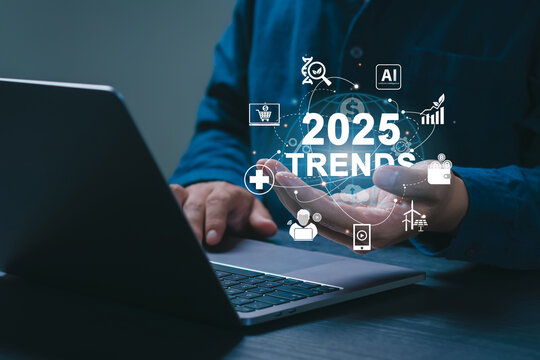 2025 Trends concept. Businessman working on laptop and holding "2025 TRENDS" icons on sgreen. future technological advancements. World business trend online technology. New business opportunities.