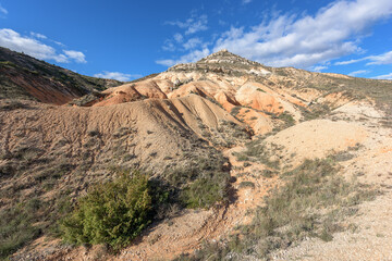 Eroded mounds with gullies and ravines in the desert of Valle de las Navas, Burgos, under a blue sky