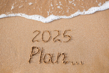 The inscription 2025, plan on the sand by the sea. Happy New Year.