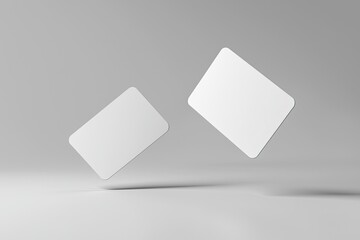two blank business card mockups floating on a grey background with a soft shadow, two white round-cornered cards flying in the air for design presentation and branding mock-up template