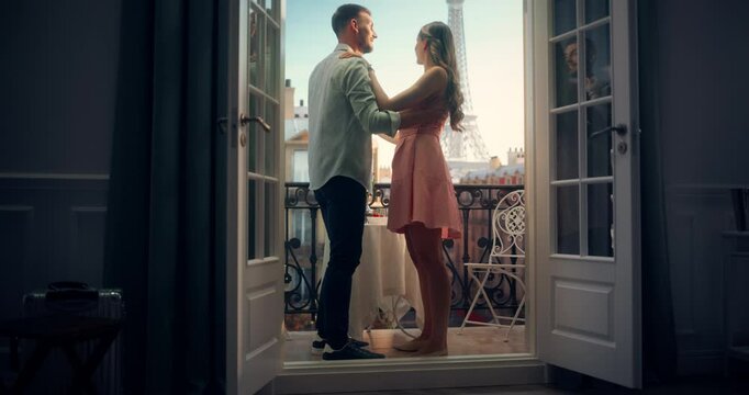 Caucasian Man and Woman Sway to Music on a Balcony Overlooking Paris and Eiffel Tower. Their Dance Becomes a Beautiful Celebration of Love and Connection. Couple on a Honeymoon Trip to France