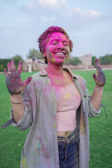 Portrait of Happy young indian woman covered with colorful powder or gulal celebrating holi festival of colors. Culture of india.