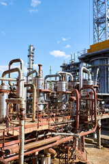 Old distillation column towers and reactors under blue evening sky background at chemical plant....