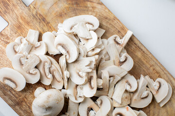Sliced white mushrooms on a wooden cutting board, perfect for vegetarian recipes or healthy cooking concepts