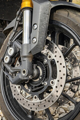 Obraz premium Motorcycle front wheel with spokes and brakes assembled.
