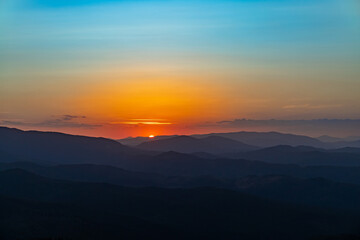 Sunset on the top of the mountain, mountain peaks on the background of the mountain landscape.