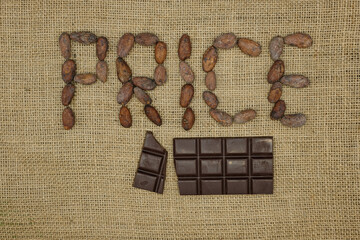 Broken Chocolate Bar and Word Price from Cocoa Beans. Jute Fabrick Background. Top View.