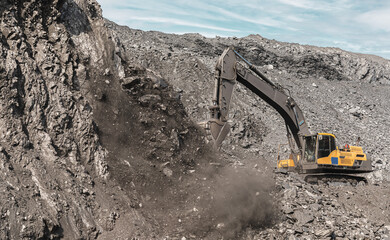 Large quarry dump excavator. Big yellow mining excavator at work site. Loading coal into body...