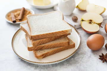 Sliced toast bread on a plate for breakfast, making of sweet French toast dessert with apples