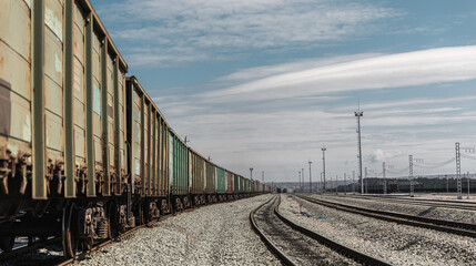 Panorama railroad tracks with wagons and railway transport. View to railway station with railroad tracks with wagons. Loading railway cars. Railway wagons standing at the station waiting for loading