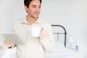 Man, tablet and coffee in morning, bedroom and reflection with smile, application or drink in home. Person, pajamas and digital touchscreen with tea cup, relax and happy on social media at apartment