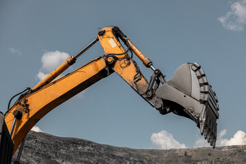 Large quarry dump excavator. Big yellow mining excavator at work site. Loading coal into body truck. Mining digger, mining machinery to loading rock. Production useful minerals