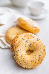Bagel sprinkled with fried onion, sesame and poppy seeds on kitchen table.