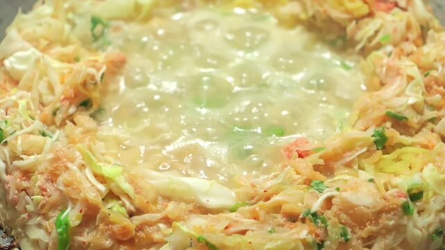 Monjayaki, a traditional Japanese dish similar to okonomiyaki, cooked with flour, water, cabbage, and seafood as ingredients