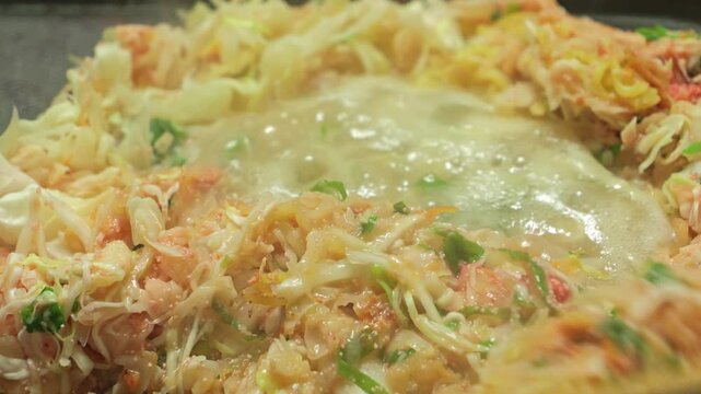 Cooking scene of monjayaki, often used for okonomiyaki
