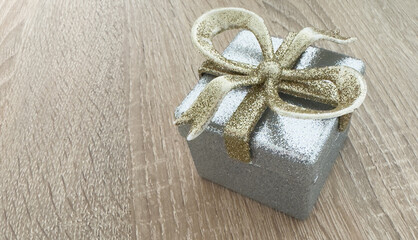 Gift box with silver ribbon bow on white background.