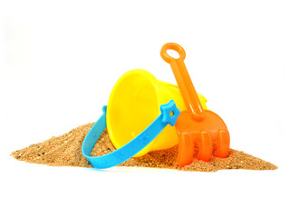 Plastic beach toys on pile of sand isolated on white background, Side view