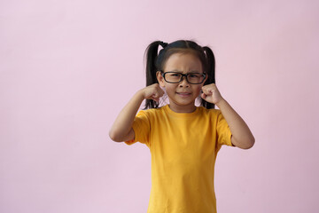 Little girl wearing glasses suffering from headache, hopeless, angry, and stressed because of pain...