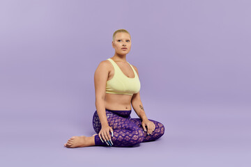 A bald woman in a yellow top and colorful leggings exudes confidence in a serene pose.