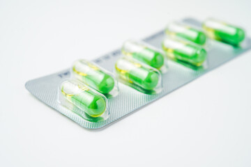 transparent gelatin capsules on white background..Oil filled blister pack green softgel food supplements