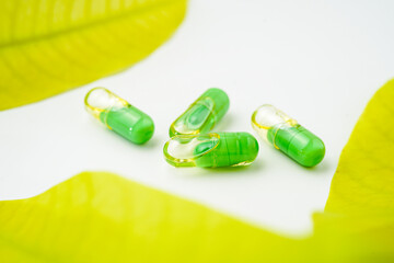 transparent pills with a mixture of green powder and oil, Food supplements, vitamins and minerals
